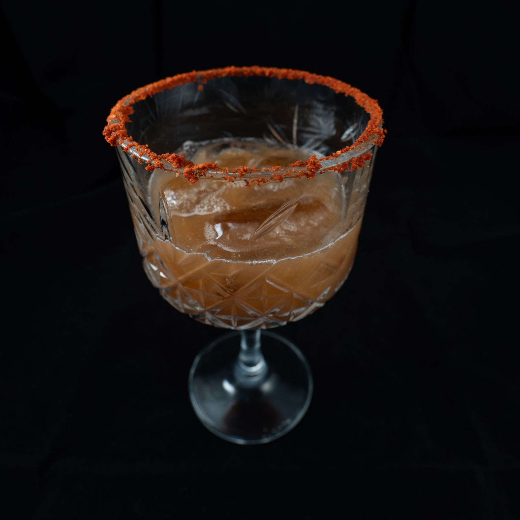 Cocktail with ice and a spiced rim