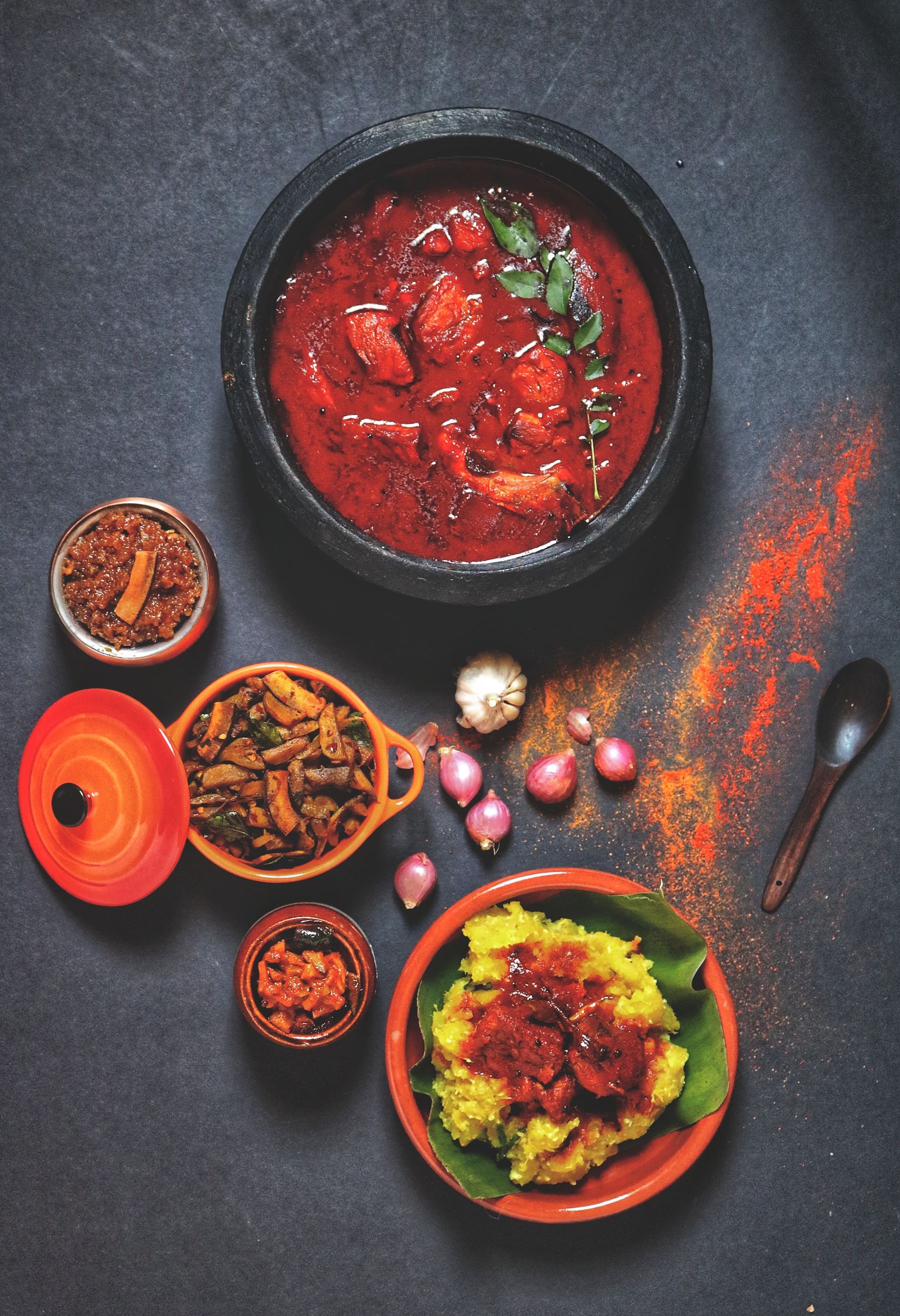 Bowls of spicy dishes on a dark surface